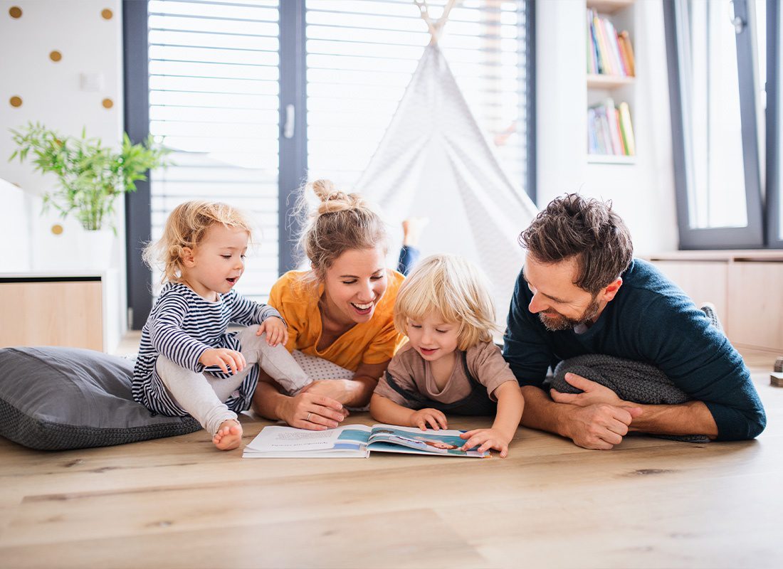Insurance Solutions - Young Family With Two Small Children Spending Time Together Inside Their Home